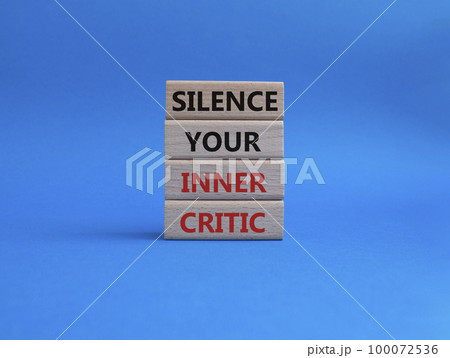 Silence your inner critic symbol. Wooden blocks with words Silence your inner critic. Beautiful blue background. Business and Silence your inner critic concept. Copy space. 100072536
