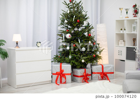 Bright living room with Christmas decorations and gifts under the tree. Bright living room with Christmas decorations and gifts under the tree. 100074120