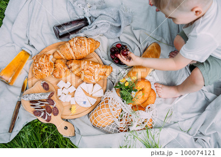 Boy child preschooler on a picnic. Smiles, eating cherries and enjoying summer. Boy child preschooler on a picnic. Smiles, eating cherries and enjoying summer. 100074121