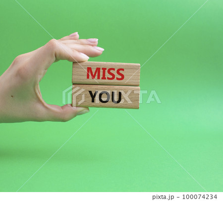 Miss you. Concept word Miss you on wooden cubes. Beautiful green background. Businessman hand. Business and Miss you concept. Copy space. Miss you. Concept word Miss you on wooden cubes. Beautiful green background. Businessman hand. Business and Miss you concept. Copy space. 100074234