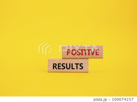 Positive results symbol. Concept words 'Positive results' on wooden blocks. Beautiful yellow background. Business and Positive results concept. Copy space. 100074257
