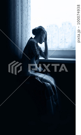 Sad girl at the window Sad girl at the window 100074938