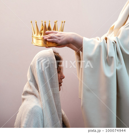 Hands placing a crown on a woman's head Hands placing a crown on a woman's head 100074944