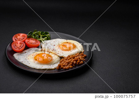Delicious hearty breakfast consisting of two fried eggs, canned lentils and microgreens 100075757