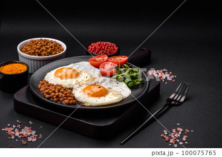 Delicious hearty breakfast consisting of two fried eggs, canned lentils and microgreens 100075765