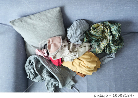 Messy clothes on sofa at home  100081847