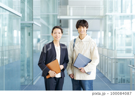 スーツ姿の女性と20代男性 スーツ姿の女性と20代男性 100084087