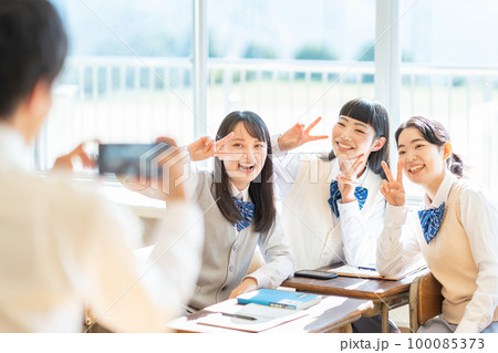 教室でスマホで写真を撮る女子高生 100085373