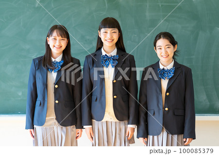 黒板の前に立つ制服姿の女子高生 100085379