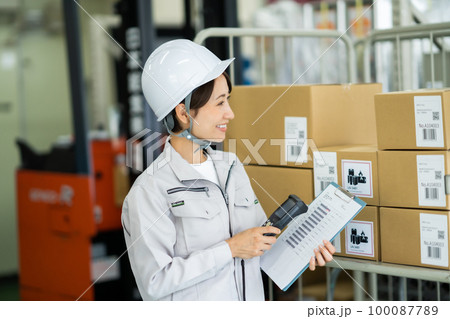 端末を持って検品をする女性スタッフ 100087789