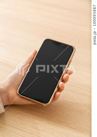 スマホを持つ若い女性の手元 100093887