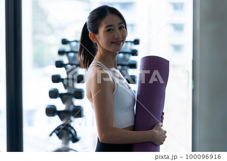 スポーツジムでトレーニングする若い女性 100096916