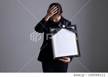 遺影を持って泣く女性 portrait of the deceased 遺影を持って泣く女性 portrait of the deceased 100098111