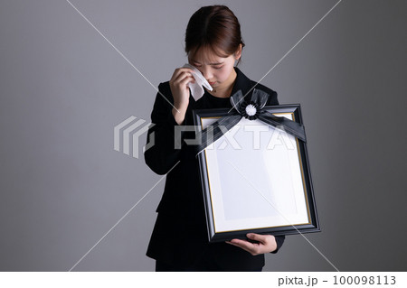 遺影を持って泣く女性 portrait of the deceased 遺影を持って泣く女性 portrait of the deceased 100098113