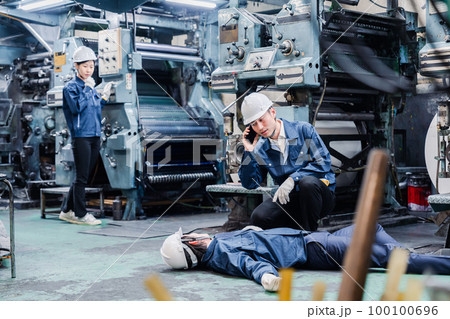 工場で救急通報をする従業員 100100696