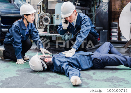 工場で救急通報をする従業員 100100712