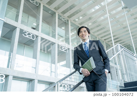 オフィスビルの階段に立つミドルエイジのビジネスマンのポートレート オフィスビルの階段に立つミドルエイジのビジネスマンのポートレート 100104072