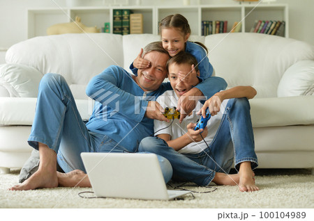 dad and kids have fun playing with a laptop  100104989
