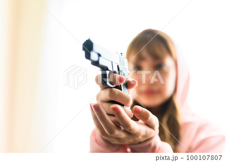 銃を構えた女性の映画のようなワンシーン 銃を構えた女性の映画のようなワンシーン 100107807