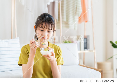 ヨーグルトを食べる若い女性 ヨーグルトを食べる若い女性 100108529