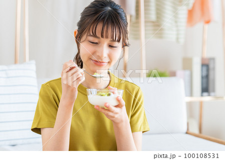 ヨーグルトを食べる若い女性 100108531