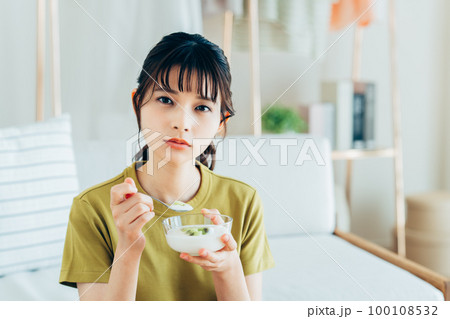 ヨーグルトを食べる若い女性 ヨーグルトを食べる若い女性 100108532