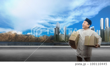 Asian Muslim man carrying box ready to mudik on the street 100110445