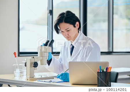 実験データをメモする白衣の若い男性 実験データをメモする白衣の若い男性 100114201