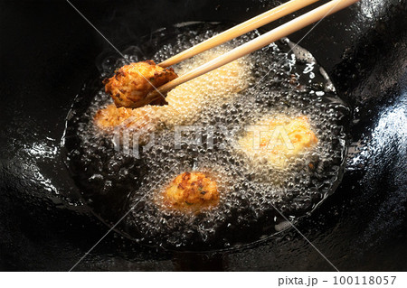 揚げたての揚げ物と調理中の油の入った天ぷら鍋 - 野菜入りのチキンナゲット･フリッター 100118057