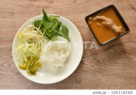 rice noodles with spicy chicken curry sauce and fresh vegetable on plate 100118268