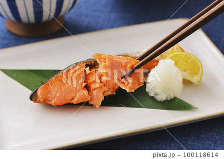 箸で持ち上げた鮭の焼き魚 100118614