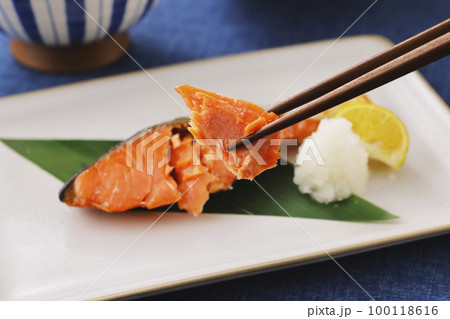 箸で持ち上げた鮭の焼き魚 100118616