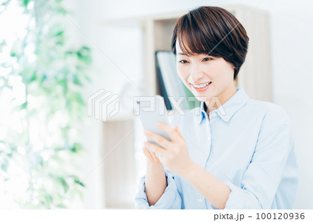 スマートフォンを操作するミドル女性 100120936