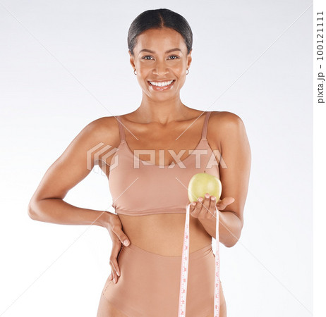Health diet, apple and happy woman with tape measure to track weight loss transformation, fitness model or body goals. Fruit detox, vegan healthcare food and portrait girl with nutritionist lifestyle 100121111