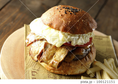 タルタルソースがはみ出ててベーコンとレタスとトマトがはさまったBLTバーガーとフライドポテト タルタルソースがはみ出ててベーコンとレタスとトマトがはさまったBLTバーガーとフライドポテト 100121151