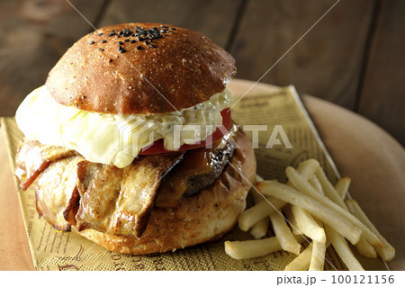 タルタルソースがはみ出ててベーコンとレタスとトマトがはさまったBLTバーガーとフライドポテト タルタルソースがはみ出ててベーコンとレタスとトマトがはさまったBLTバーガーとフライドポテト 100121156
