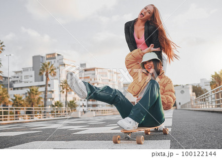 Fun, comic and portrait of friends on a skateboard for the weekend, bonding and playing in the city. Energy, smile and crazy women skateboarding for funny activity, happiness and playful in Sweden 100122144