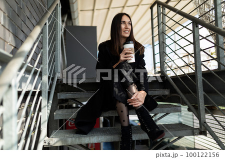 coffee break of a young adult on the steps of a business center 100122156