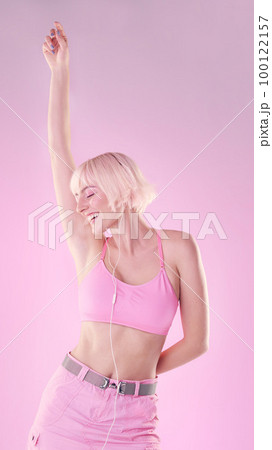 Fashion, woman and dancing with earphones, freedom and celebration on studio background. Female, confident lady or dancer with headset, music or streaming for audio, carefree or happiness on backdrop 100122157