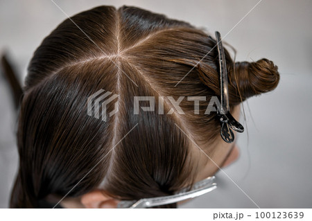 young girl gets fashionable haircut in modern salon 100123639