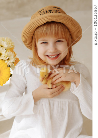 A cheerful child holds a live duck in his hands 100125867