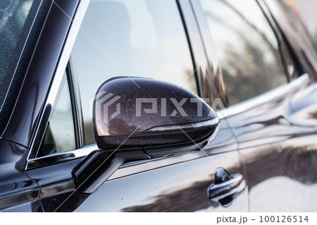 Close up front view of car side mirror. Front rear view mirror on the car window. Car exterior details. Close up front view of car side mirror. Front rear view mirror on the car window. Car exterior details. 100126514