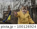 Little girl in front of defensive structures of Ukrainian army. War in Ukraine. Children and war concept. Support for Ukraine. Stop war. Humanitarian disaster concept. Ukrainian flag 100126924