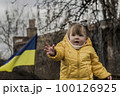 Little girl in front of defensive structures of Ukrainian army. War in Ukraine. Children and war concept. Support for Ukraine. Stop war. Humanitarian disaster concept. Ukrainian flag 100126925