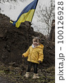 Little girl in front of defensive structures of Ukrainian army. War in Ukraine. Children and war concept. Support for Ukraine. Stop war. Humanitarian disaster concept. Ukrainian flag 100126928