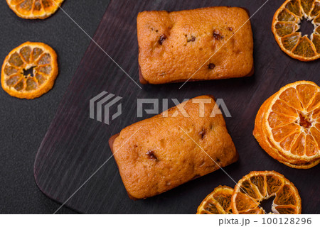 Delicious chocolate muffins and dried round shaped slices of tangerine 100128296