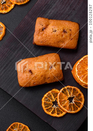 Delicious chocolate muffins and dried round shaped slices of tangerine 100128297