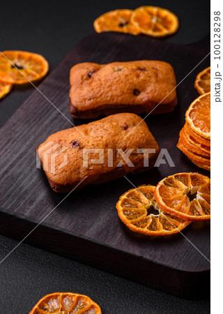 Delicious chocolate muffins and dried round shaped slices of tangerine 100128298