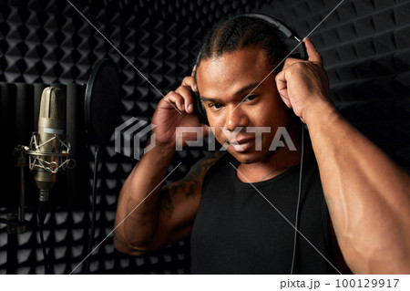 African American at the recording studio in headphones reads rap African American at the recording studio in headphones reads rap 100129917