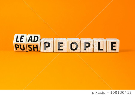 Lead or push people symbol. Concept word Lead people and Push people on wooden cubes. Beautiful orange table orange background. Business Energy or hunger crisis concept. Copy space. 100130415